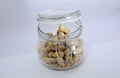 Glass jar with lots of peanuts on a white background Royalty Free Stock Photo